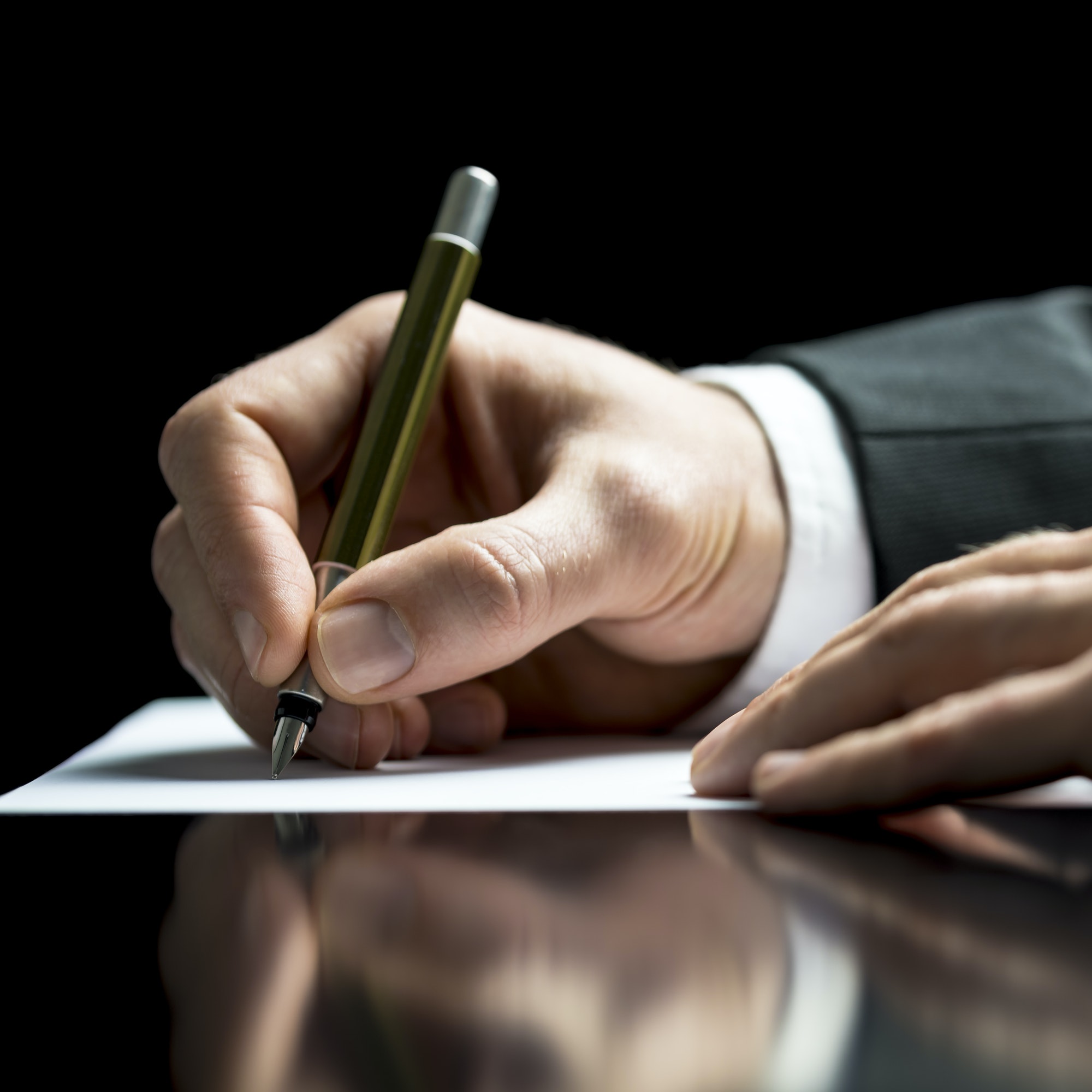 Businessman writing on a sheet of white paper