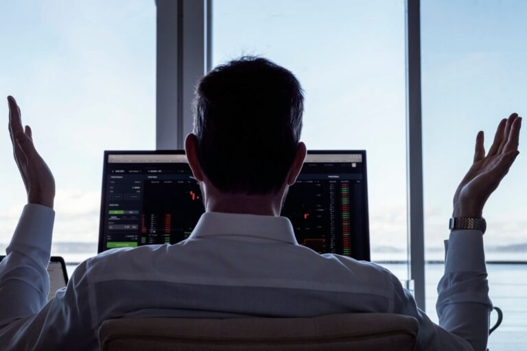 Hands up businessman at desk with computers